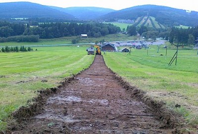 Die professionelle Variante erfordert einige Erdarbeiten um eine kurvenreiche Tubing-Bahn herzustellen. Hügelige  Geländeformen können kostensparend genutzt werden. 