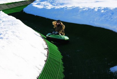 Tubing Bahn mit rutschenden Gästen im Tubing-Reifen