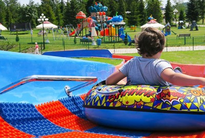 Rutschendes Kind im Tubing Reifen auf der Tubing Bahn